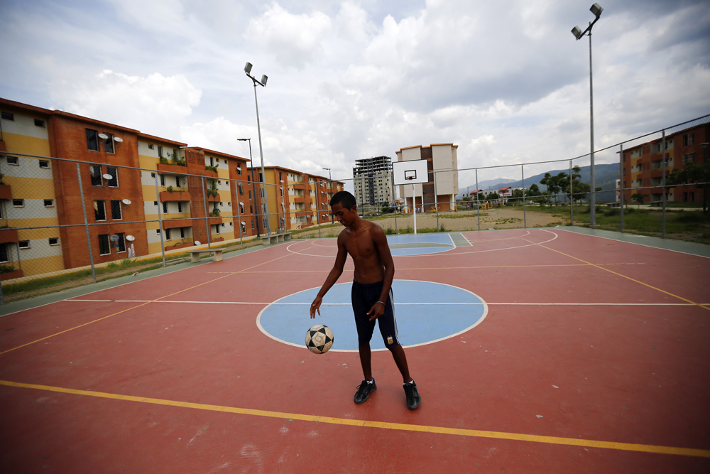 A boy plays with a ball in Ciudad Caribia outside Caracas